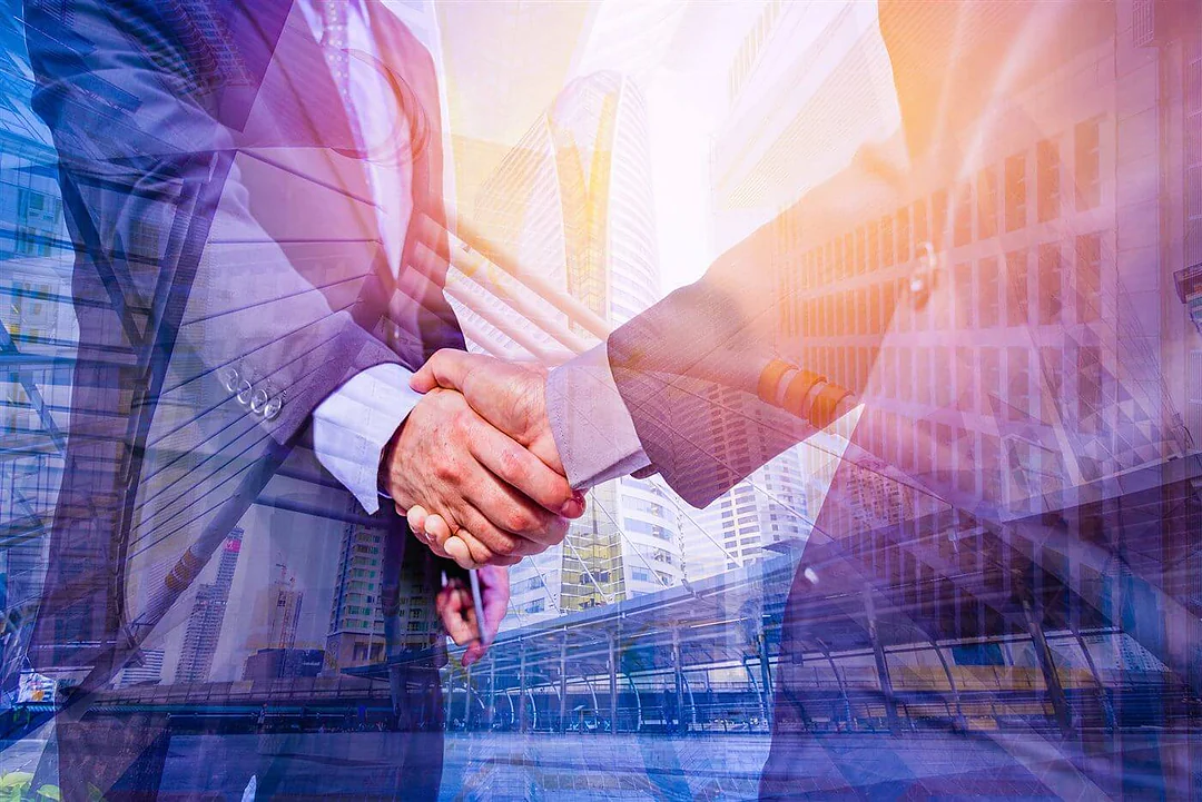 Business handshake against a city skyline backdrop